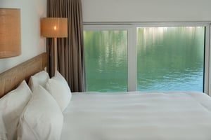 Camera Riflesso di Villa Patria con letto matrimoniale, arredi in legno e vista sul Lago di Lugano