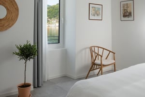 Camera Brezza di Villa Patria con letto matrimoniale, arredi in legno e vista sul Lago di Lugano