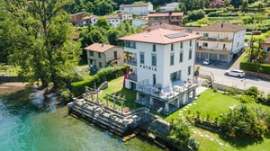 Vista aerea di Villa Patria sul Lago di Lugano, con giardino e terrazza affacciati sull’acqua.