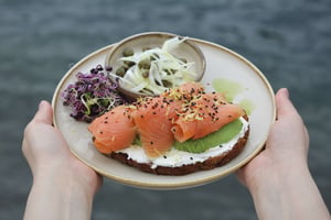Ein leckeres Gericht mit Avocado-Toast mit Lachs, serviert mit einem Salat aus blanchierten Zwiebeln und Kapern
